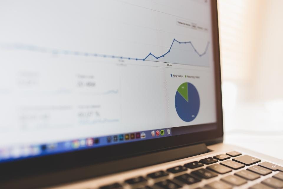 Laptop screen showing a reporting dashboard with charts and statistics