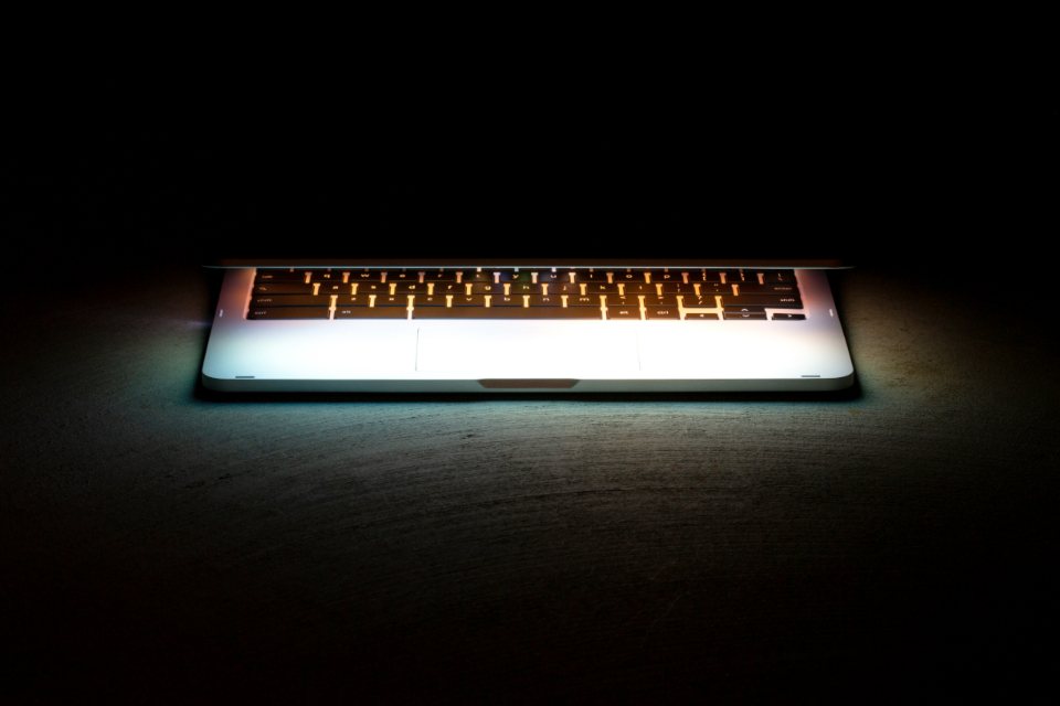 Backlit laptop keyboard glowing in the dark, symbolising business cybersecurity